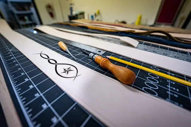 Layout: Patterns and designs laid out on raw craftsman leather before cutting.